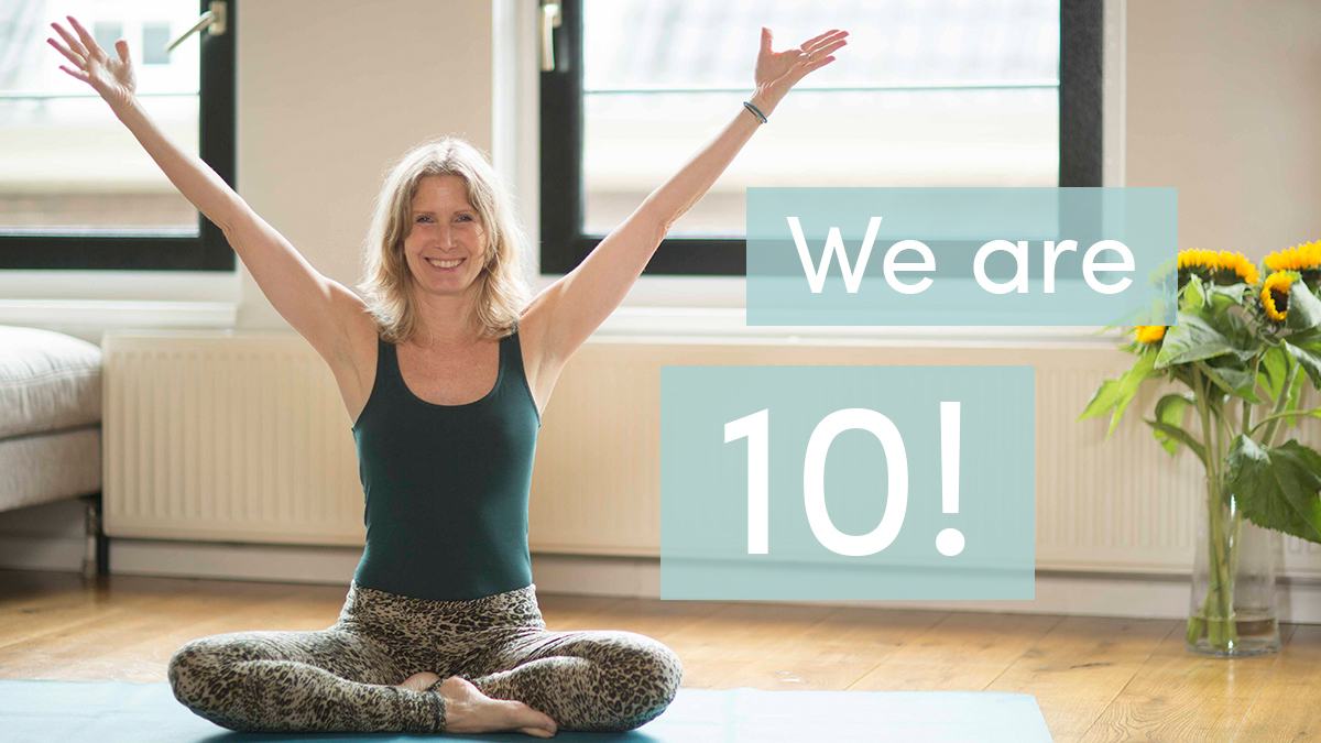 Esther Ekhart raising her hands in celebration of 10 years of EkhartYoga