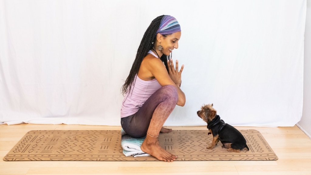 Garland pose with a blanket under the heels and a dog watching