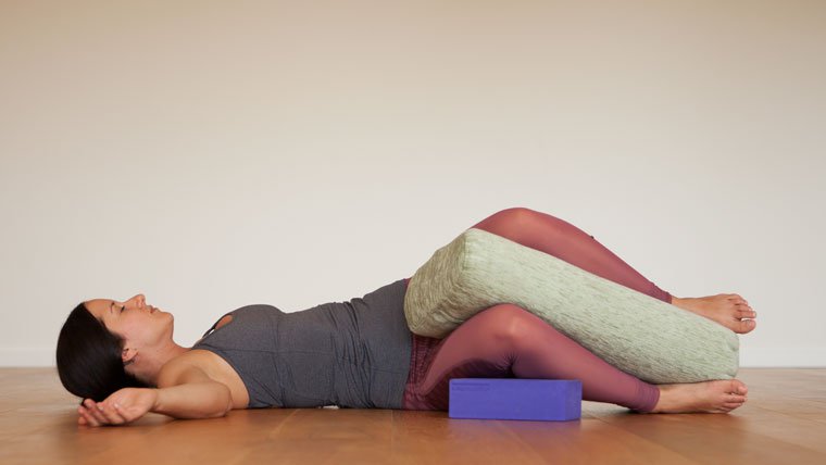 Restorative twist with bolster between knees