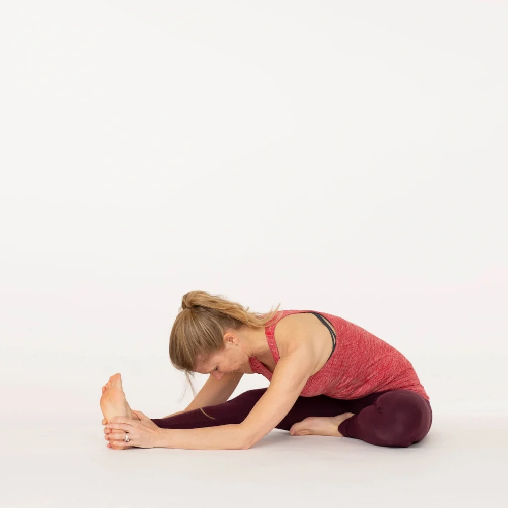 Fit woman sitting in butterfly pose and pressing on legs · Free Stock Photo