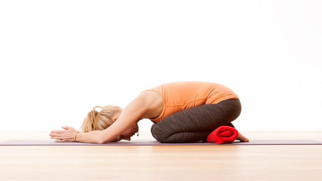 Childs pose with a blanket under the ankles